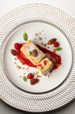 Cevizli, ahududulu, beyaz çikolatalı kek. Noel süslemeleri ile birlikte en üstteki masa..