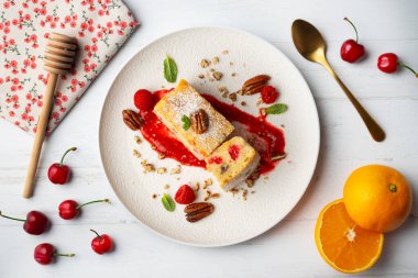 Cevizli, ahududulu, beyaz çikolatalı kek. Noel süslemeleri ile birlikte en üstteki masa..