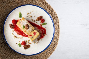 Cevizli, ahududulu, beyaz çikolatalı kek. Noel süslemeleri ile birlikte en üstteki masa..