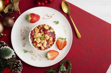 Bireysel fırında pişmiş çilek parçaları. Noel süslemeleri ile en üstteki görünüm masası.