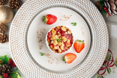 Bireysel fırında pişmiş çilek parçaları. Noel süslemeleri ile en üstteki görünüm masası.