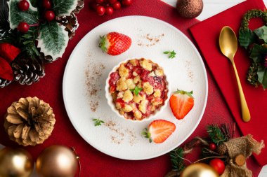 Bireysel fırında pişmiş çilek parçaları. Noel süslemeleri ile en üstteki görünüm masası.