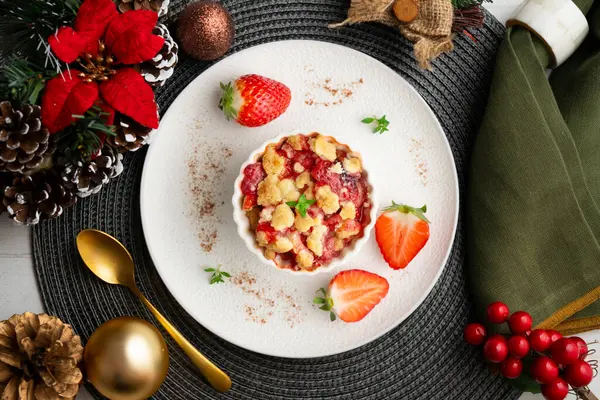 Bireysel fırında pişmiş çilek parçaları. Noel süslemeleri ile en üstteki görünüm masası.