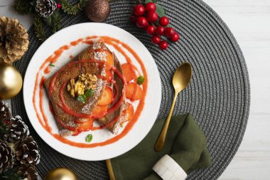 Çilek ve meyve sosuyla dolu çikolatalı krepler. Noel süslemeleri ile en üstteki görünüm masası.