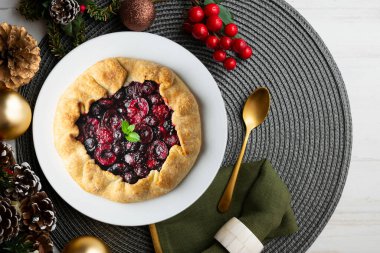 Kırmızı çilekli turta, kiraz, ahududu ve böğürtlenli. Noel süslemeli en iyi manzara masası.