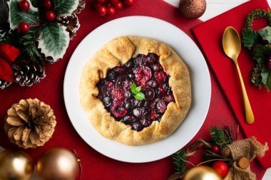 Kırmızı çilekli turta, kiraz, ahududu ve böğürtlenli. Noel süslemeli en iyi manzara masası.