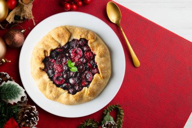 Kırmızı çilekli turta, kiraz, ahududu ve böğürtlenli. Noel süslemeli en iyi manzara masası.