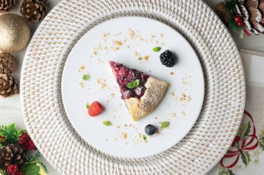 Kırmızı çilekli turta, kiraz, ahududu ve böğürtlenli. Noel süslemeli en iyi manzara masası.