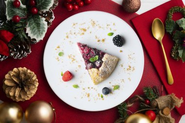 Kırmızı çilekli turta, kiraz, ahududu ve böğürtlenli. Noel süslemeli en iyi manzara masası.