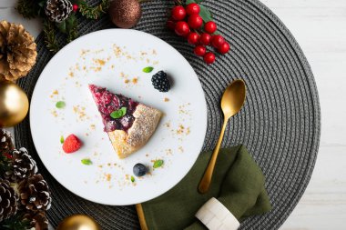 Kırmızı çilekli turta, kiraz, ahududu ve böğürtlenli. Noel süslemeli en iyi manzara masası.