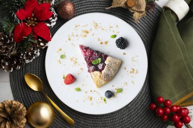 Kırmızı çilekli turta, kiraz, ahududu ve böğürtlenli. Noel süslemeli en iyi manzara masası.