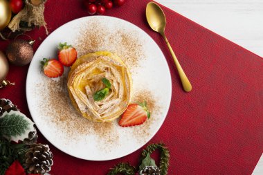 Kremayla doldurulmuş filo pastasından yapılmış çiçek şeklinde tart. Noel süslemeleri ile en üstteki görünüm masası.