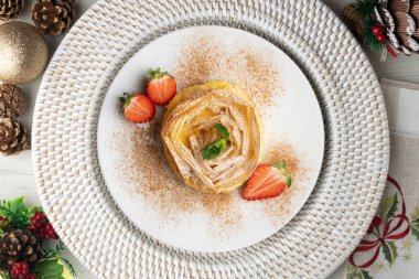 Kremayla doldurulmuş filo pastasından yapılmış çiçek şeklinde tart. Noel süslemeleri ile en üstteki görünüm masası.