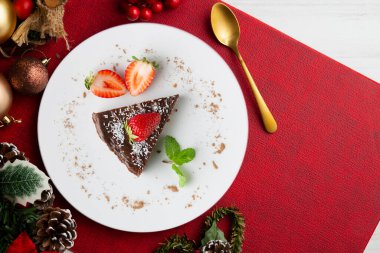 Taze çilekli çikolatalı cheesecake. Noel süslemeleri ile en üstteki görünüm masası.