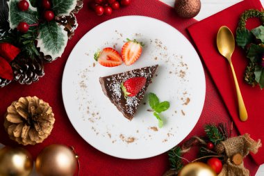 Taze çilekli çikolatalı cheesecake. Noel süslemeleri ile en üstteki görünüm masası.