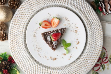 Taze çilekli çikolatalı cheesecake. Noel süslemeleri ile en üstteki görünüm masası.