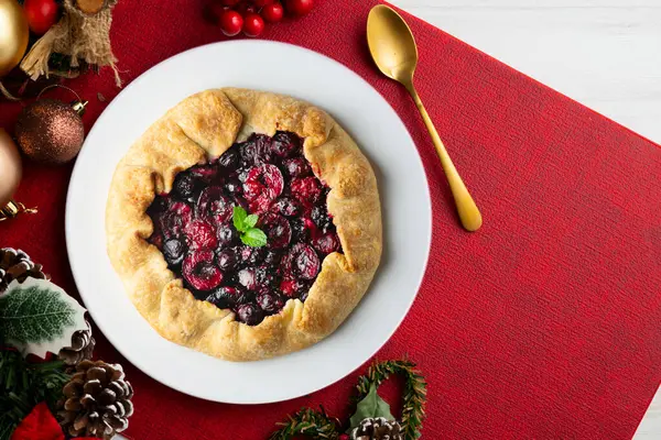 Kırmızı çilekli turta, kiraz, ahududu ve böğürtlenli. Noel süslemeli en iyi manzara masası.