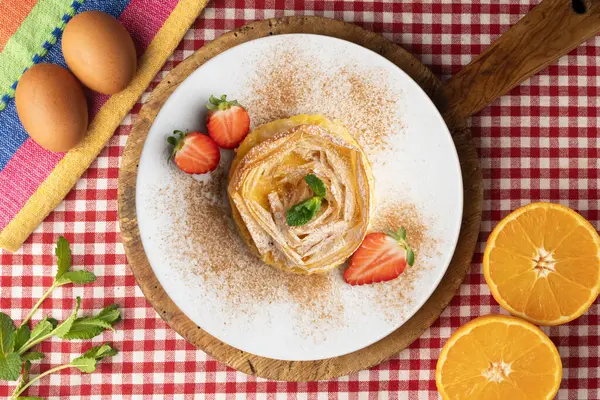 Kremayla doldurulmuş filo pastasından yapılmış çiçek şeklinde tart. Noel süslemeleri ile en üstteki görünüm masası.