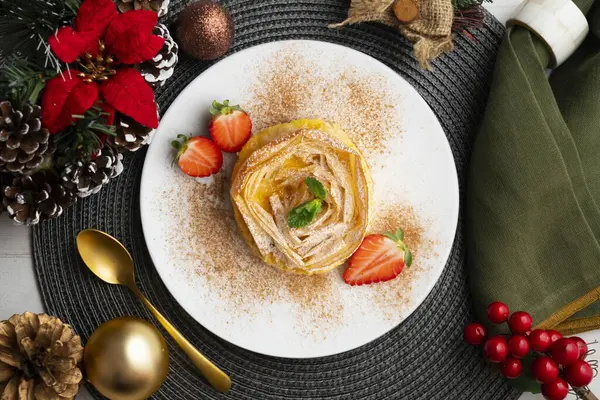 Kremayla doldurulmuş filo pastasından yapılmış çiçek şeklinde tart. Noel süslemeleri ile en üstteki görünüm masası.