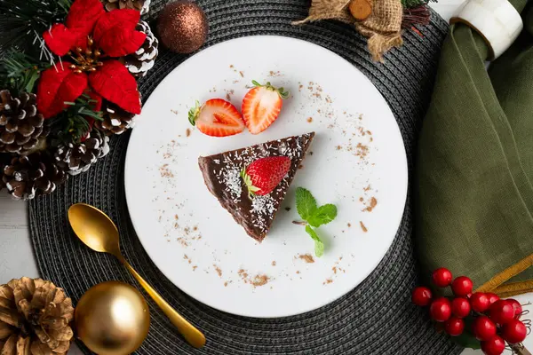Taze çilekli çikolatalı cheesecake. Noel süslemeleri ile en üstteki görünüm masası.