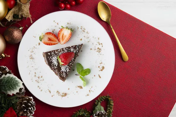 Taze çilekli çikolatalı cheesecake. Noel süslemeleri ile en üstteki görünüm masası.