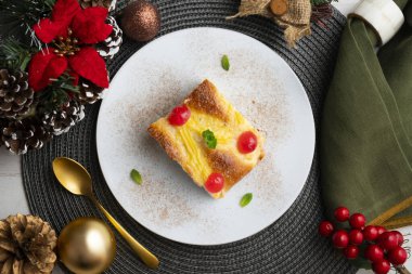 Coca San Juan, kremalı ve şekerli meyveli brioche 'ye benzer geleneksel bir Katalan tatlısıdır. Noel süslemeleri ile en üstteki görünüm masası.