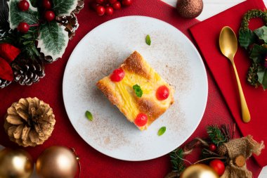 Coca San Juan, kremalı ve şekerli meyveli brioche 'ye benzer geleneksel bir Katalan tatlısıdır. Noel süslemeleri ile en üstteki görünüm masası.