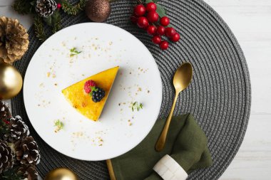 Bisküvi tabanlı yanmış Katalan kremalı tartı. Noel süslemeleri olan bir masanın üst görünümü.