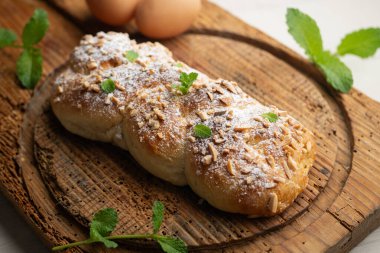 Kızarmış badem ve pudra şekerli Brioche örgüsü. Geleneksel Fransız hamur işi tarifi..