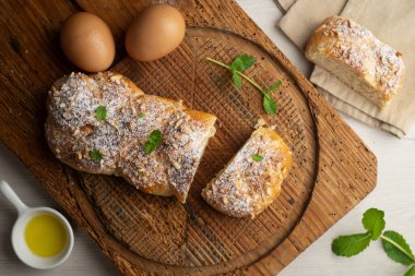 Kızarmış badem ve pudra şekerli Brioche örgüsü. Geleneksel Fransız hamur işi tarifi..