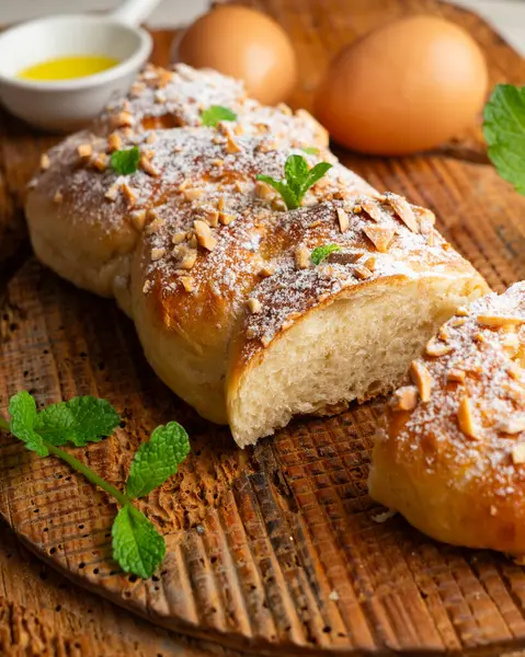 Kızarmış badem ve pudra şekerli Brioche örgüsü. Geleneksel Fransız hamur işi tarifi..