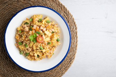 Sebzeli, yumurtalı ve jambonlu üç lezzetli pilav. Noel süslemeleri olan bir masanın üst görünümü.