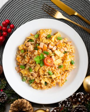 Sebzeli, yumurtalı ve jambonlu üç lezzetli pilav. Noel süslemeleri olan bir masanın üst görünümü.