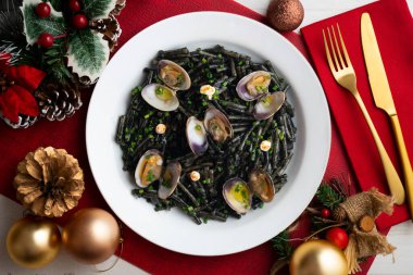 İspanyol siyah Fideua 'sı. Geleneksel erişte tarifi, midye ve sarımsak yağı. Noel süslemeleri ile en üstteki görünüm masası.