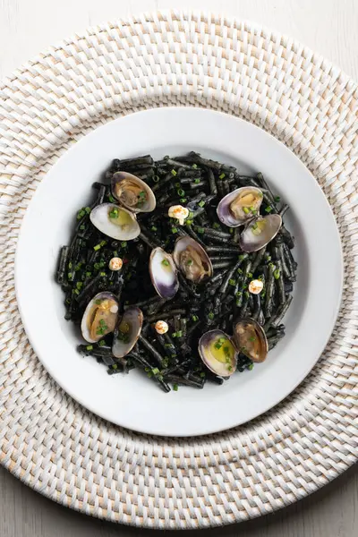 İspanyol siyah Fideua 'sı. Geleneksel erişte tarifi, midye ve sarımsak yağı. Noel süslemeleri ile en üstteki görünüm masası.