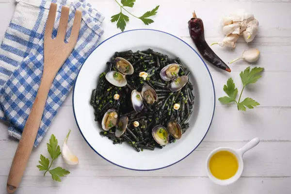 İspanyol siyah Fideua 'sı. Geleneksel erişte tarifi, midye ve sarımsak yağı. Noel süslemeleri ile en üstteki görünüm masası.