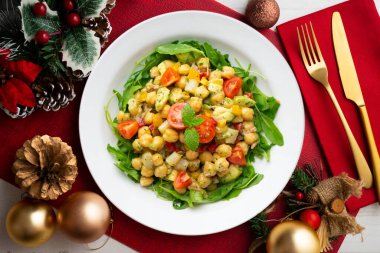 Avokado ve sebzeli Akdeniz nohut salatası. Noel süslemeleri ile en üstteki görünüm masası.