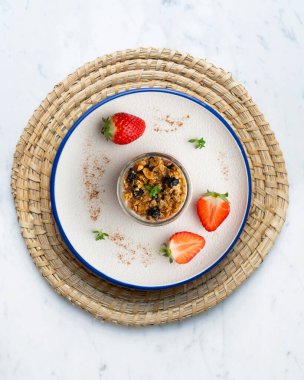 Çilekli Yunan yoğurdu ve tahıl gevreği ve fındıklı granola. Noel süslemeleri ile en üstteki görünüm masası.