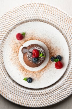 Çok güzel bir çikolatalı lav keki Noel süslemeleri ile birlikte en üstten görülebilir..