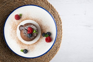 Çok güzel bir çikolatalı lav keki Noel süslemeleri ile birlikte en üstten görülebilir..