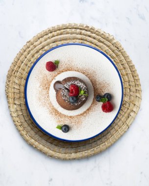 Çok güzel bir çikolatalı lav keki Noel süslemeleri ile birlikte en üstten görülebilir..