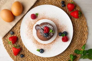 Çok güzel bir çikolatalı lav keki Noel süslemeleri ile birlikte en üstten görülebilir..