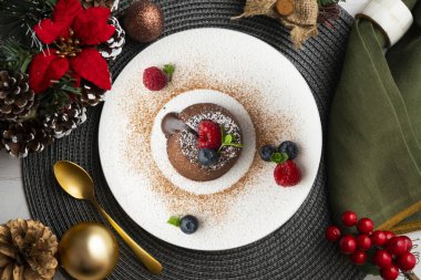 Çok güzel bir çikolatalı lav keki Noel süslemeleri ile birlikte en üstten görülebilir..