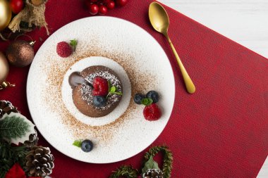 Çok güzel bir çikolatalı lav keki Noel süslemeleri ile birlikte en üstten görülebilir..