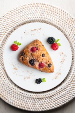 Böğürtlen, ahududu ve çikolata parçacıklı üçgen İngiliz çörekleri. Noel süslemeleri ile en üstteki görünüm masası.