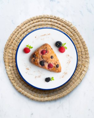 Böğürtlen, ahududu ve çikolata parçacıklı üçgen İngiliz çörekleri. Noel süslemeleri ile en üstteki görünüm masası.