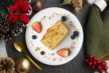 İbizan Greixonera. Balear Adaları 'ndan geleneksel ensaimada ile yumurtalı puding. Noel süslemeleri ile en üstteki görünüm masası.