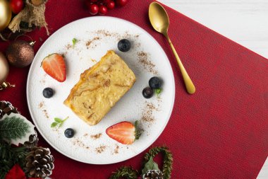 İbizan Greixonera. Balear Adaları 'ndan geleneksel ensaimada ile yumurtalı puding. Noel süslemeleri ile en üstteki görünüm masası.