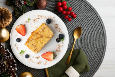 İbizan Greixonera. Balear Adaları 'ndan geleneksel ensaimada ile yumurtalı puding. Noel süslemeleri ile en üstteki görünüm masası.