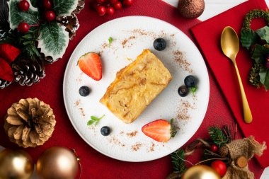 İbizan Greixonera. Balear Adaları 'ndan geleneksel ensaimada ile yumurtalı puding. Noel süslemeleri ile en üstteki görünüm masası.